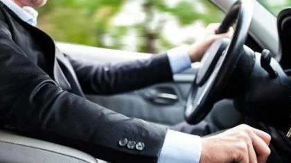 Man in pak rijdt auto – Autoverzekering – Particulier