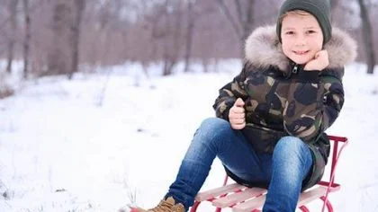 Kind op slee in sneeuw – Woonhuisverzekering – Particulier