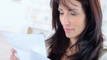 Vrouw kijkt naar document – Pensioen en inkomen – Particulier