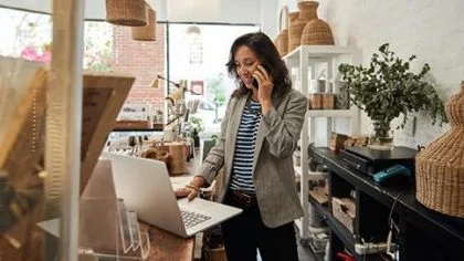 Vrouw in winkel aan telefoon – Corona – Zakelijk