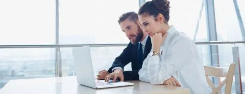 Man en vrouw achter laptop – Arbeidsongeschiktheidsverzekering – Zakelijk