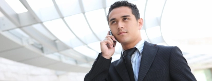 Man in pak aan telefoon – Bedrijfsschadeverzekering – Zakelijk