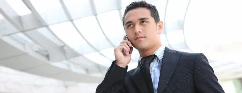Man in pak aan telefoon – Bedrijfsschadeverzekering – Zakelijk