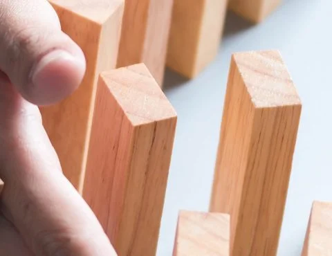 Dominosteentjes met hand ertussen om tegen te houden – Corona – Zakelijk Dominosteentjes met hand ertussen om tegen te houden – Corona – Zakelijk