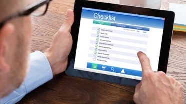 Man bekijkt checklist I-Pad – Preventieservice – Zakelijk