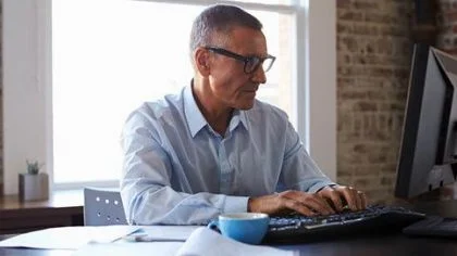 Man achter computer – Cybercrime verzekering – Zakelijk
