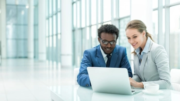 Man en vrouw achter laptop – Cybercrime verzekering – Zakelijk