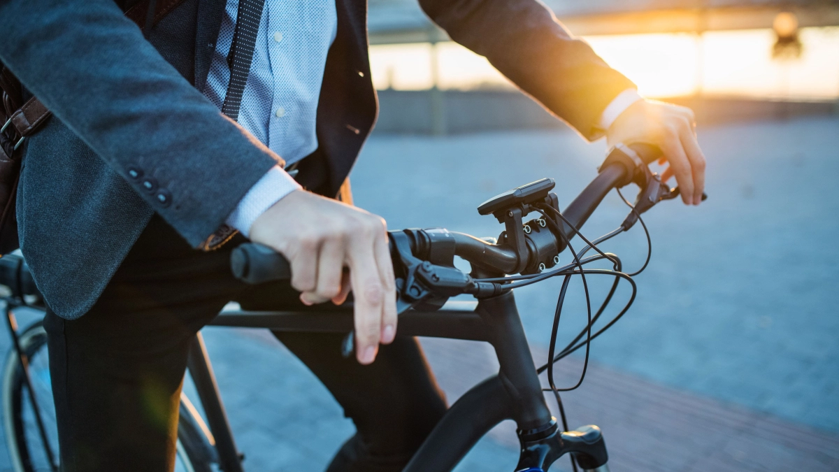 Man in pak op elektrsiche fiets – Bedrijfsaansprakelijkheidsverzekering – Zakelijk
