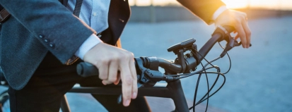 Man in pak op elektrsiche fiets – Bedrijfsaansprakelijkheidsverzekering – Zakelijk