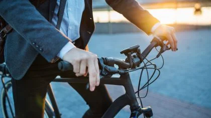 Man in pak op elektrsiche fiets – Bedrijfsaansprakelijkheidsverzekering – Zakelijk