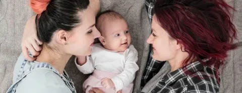 Vrouwen liggen om baby heen – Geboorteverlof – Zakelijk