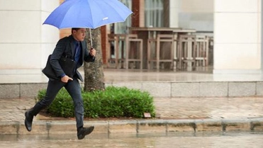 Man in regen paraplu – Gebouwenverzekering – Zakelijk