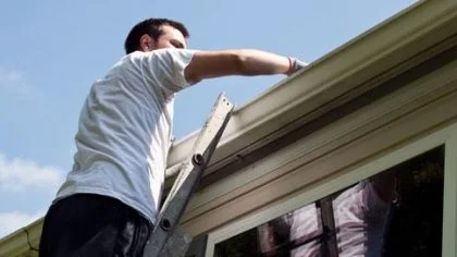 Man op ladder kijkt naar dak – Noodweer – Particulier