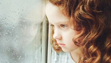 Meisje kijkt uit raam regent – Waterschade – Particulier