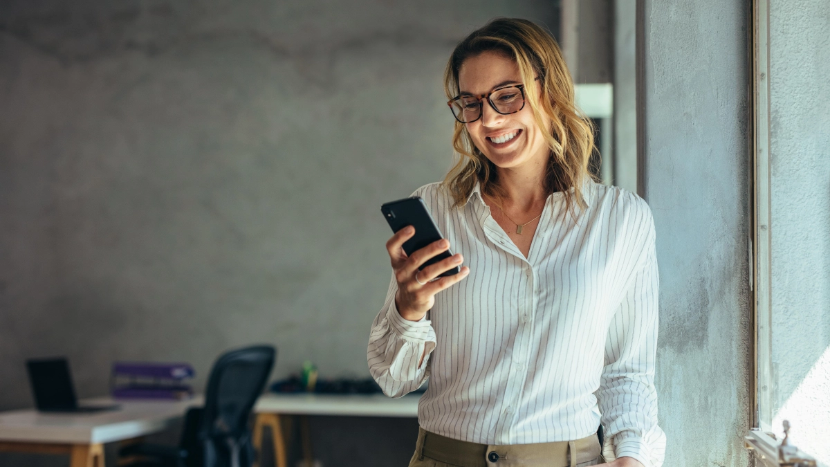 Vrouw op mobiel glimlacht – Ondernemer – Zakelijk