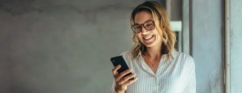 Vrouw op mobiel glimlacht – Ondernemer – Zakelijk