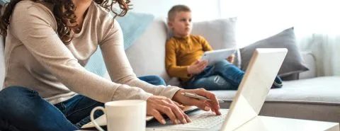 Vrouw op laptop zoon op I-pad – Pensioen en inkomen – Particulier