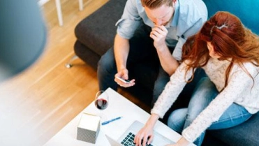 Man en vrouw op bank op laptop – Hypotheek – Zakelijk