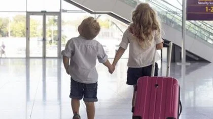 Kinderen hand in hand met koffer vast op vliegveld – Klant – Zicht
