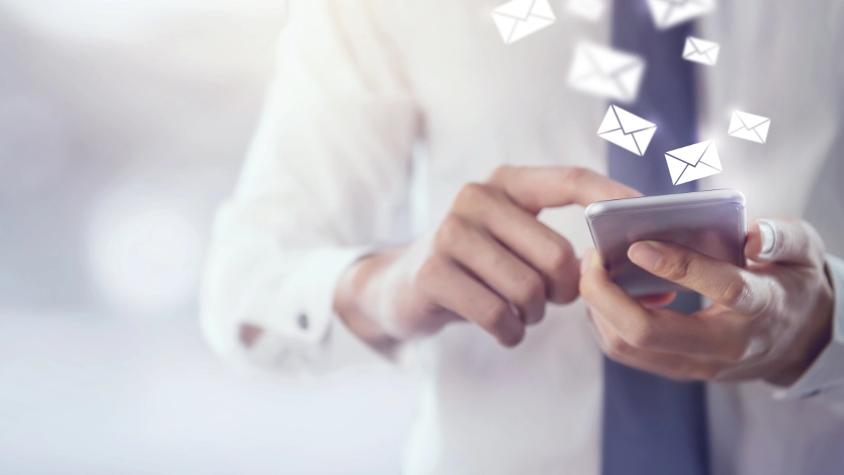 Man op mobiel krijgt e-mails binnen – Contact – Zakelijk