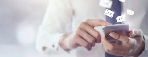 Man op mobiel krijgt e-mails binnen – Contact – Zakelijk