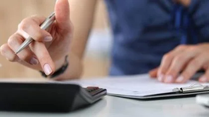 Vrouw typt op rekenmachine – Pensioen en inkomen – Particulier