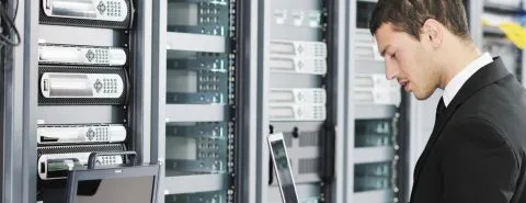 Man met laptop in datacenter – Specialismen – Zakelijk