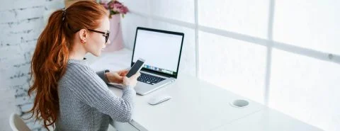 Vrouw aan bureau op laptop – Pensioen en inkomen – Particulier