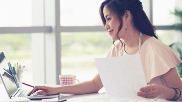 Vrouw achter bureau op laptop – Reconstructieverzekering – Zakelijk