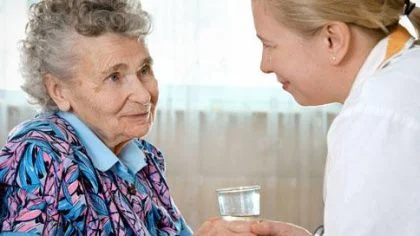 Oudere vrouw krijgt water van verpleegster – Specialismen – Zakelijk