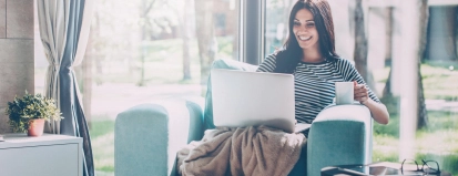 Vrouw met laptop en kop drinken op bank – Hypotheek – Particulier