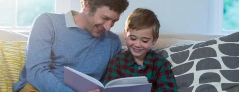 Man leest zoon boek voor op bank – MijnZicht