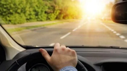 Iemand achter het stuur, zon schijnt – Bedrijfsautoverzekering – Zakelijk
