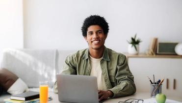 Man aan tafel achter laptop – Verzekeringspakket – Particulier