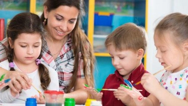 Kinderen verven in kinderdagverblijf met begeleidster – Specialismen – Zakelijk