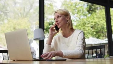 Vrouw aan telefoon op laptop – Pensioen en inkomen – Particulier