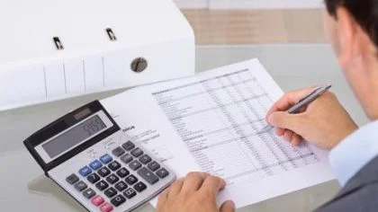 Man bekijkt document en rekenmachine – Kredietverzekering – Zakelijk