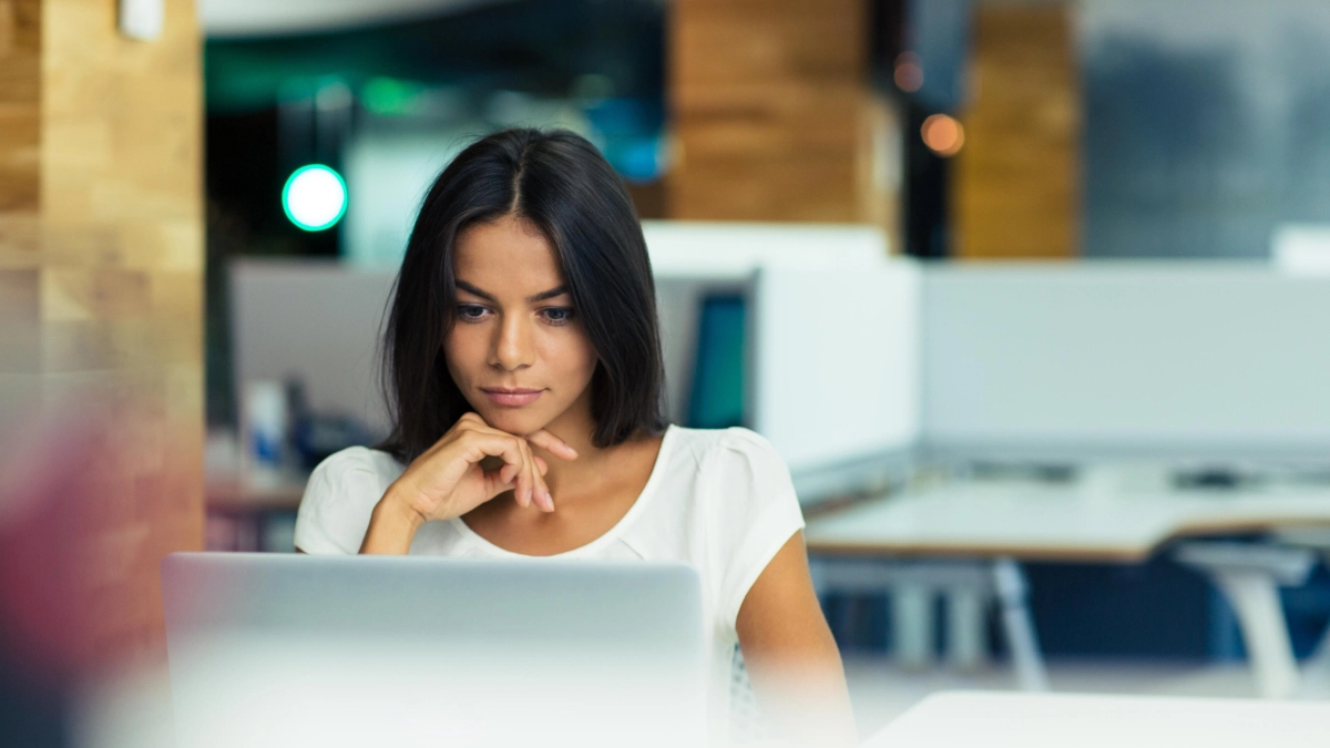 Vrouw achter laptop op werk – Ziekengeldverzekering – Zakelijk