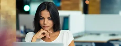 Vrouw achter laptop op werk – Ziekengeldverzekering – Zakelijk
