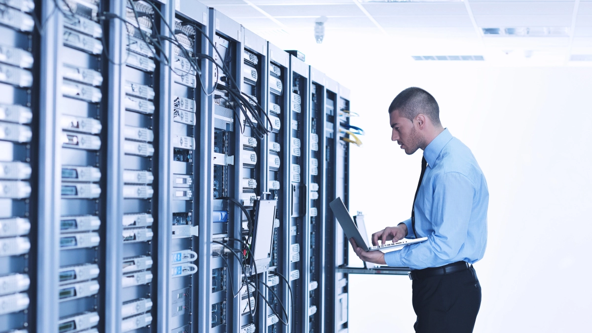 Man met laptop in data center – Cybercrime verzekering – Zakelijk