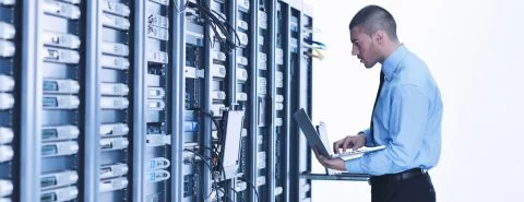 Man met laptop in data center – Cybercrime verzekering – Zakelijk