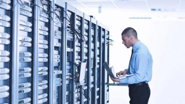 Man met laptop in data center – Cybercrime verzekering – Zakelijk