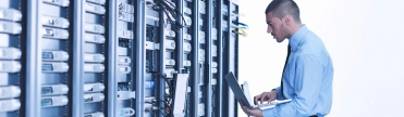 Man met laptop in data center – Cybercrime verzekering – Zakelijk