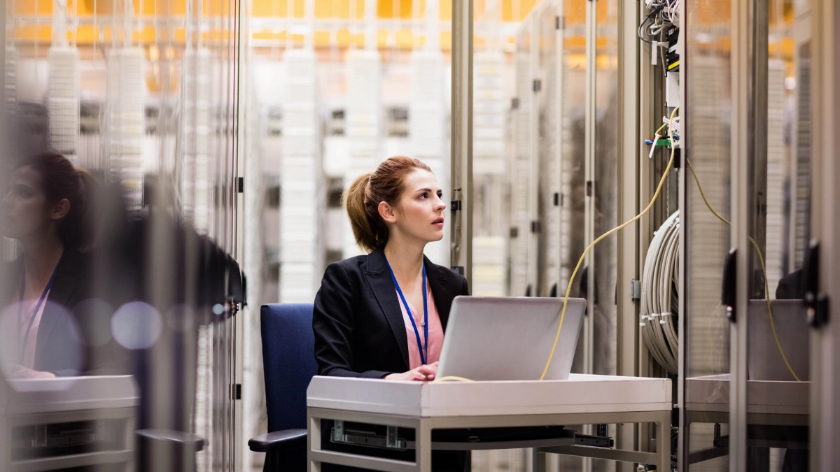 Vrouw achter laptop in datacenter – Specialismen – Zakelijk