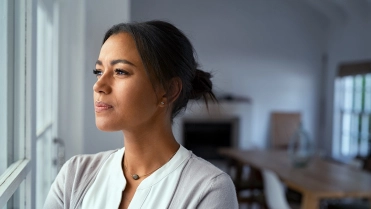 vrouw kijkt uit raam