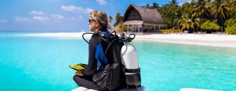 Man duikend in een tropisch oord – wanneer heeft u een reisverzekering nodig?