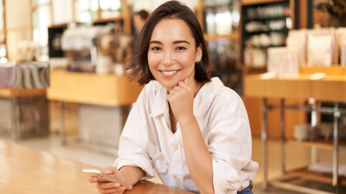 Portrait,Of,Asian,Businesswoman,,Sitting,On,Table,In,Cafe,,Drinking