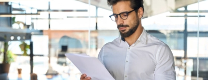 Serious,Young,Latin,Business,Man,Checking,Financial,Documents,In,Office.