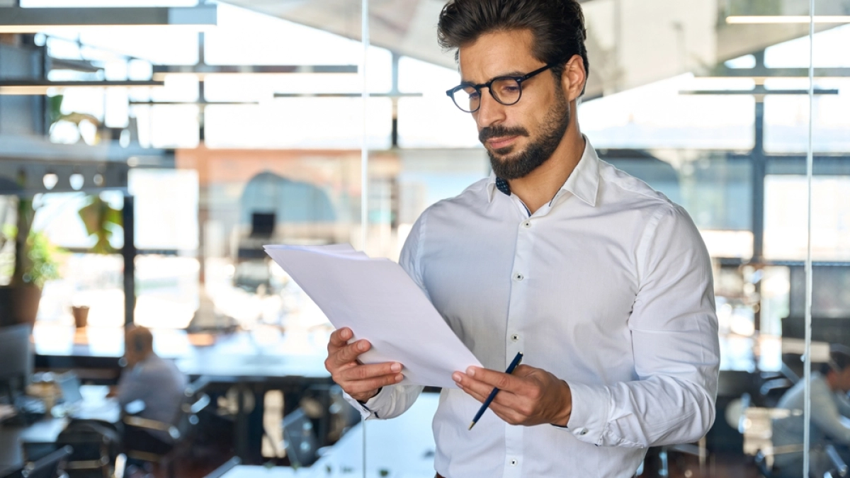 Serious,Young,Latin,Business,Man,Checking,Financial,Documents,In,Office.