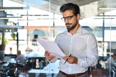 Serious,Young,Latin,Business,Man,Checking,Financial,Documents,In,Office.